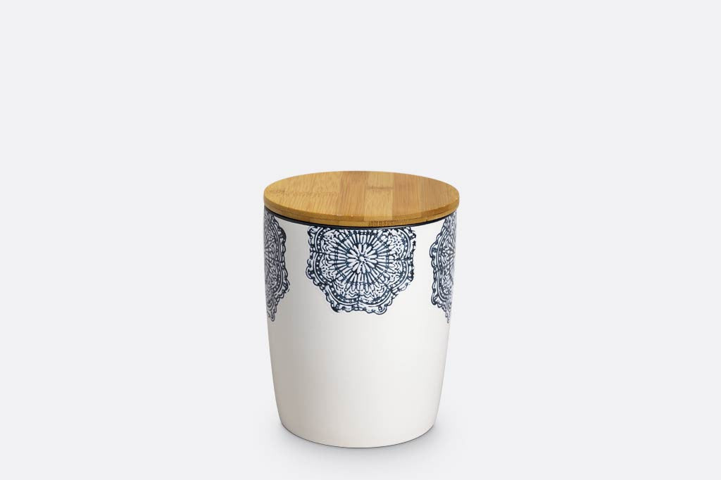 canister of white ceramic with blue mediterranean glazed print and blue rim; has wood lid