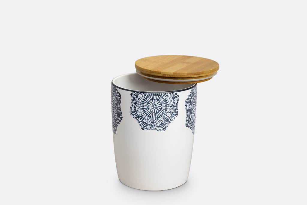canister of white ceramic with blue mediterranean glazed print and blue rim; has wood lid