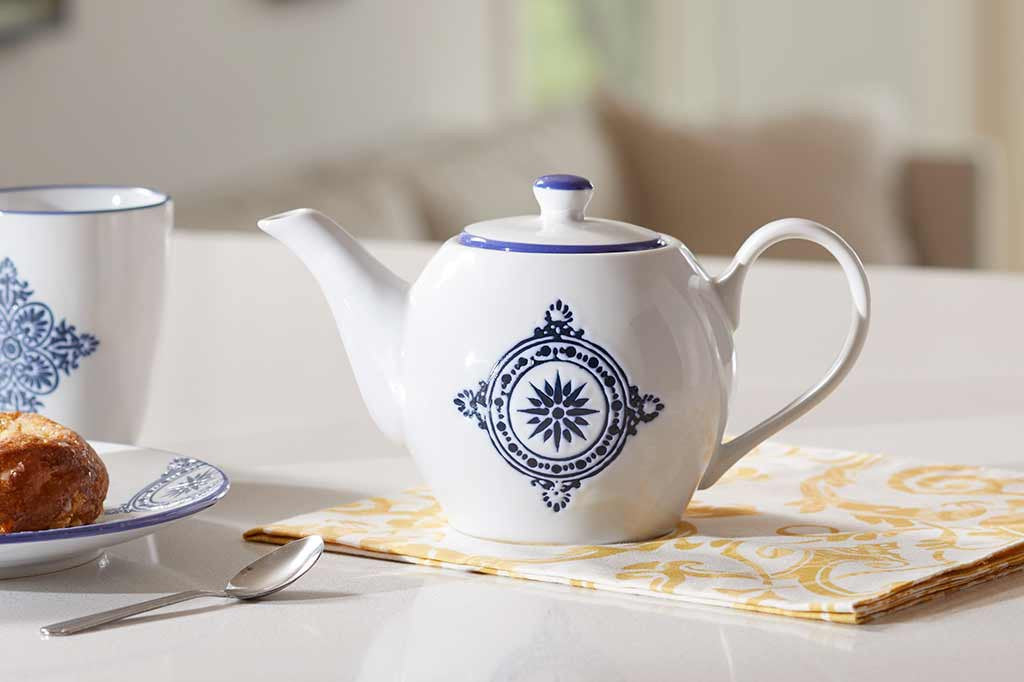 teapot of white ceramic with blue mediterranean glazed print and blue rim