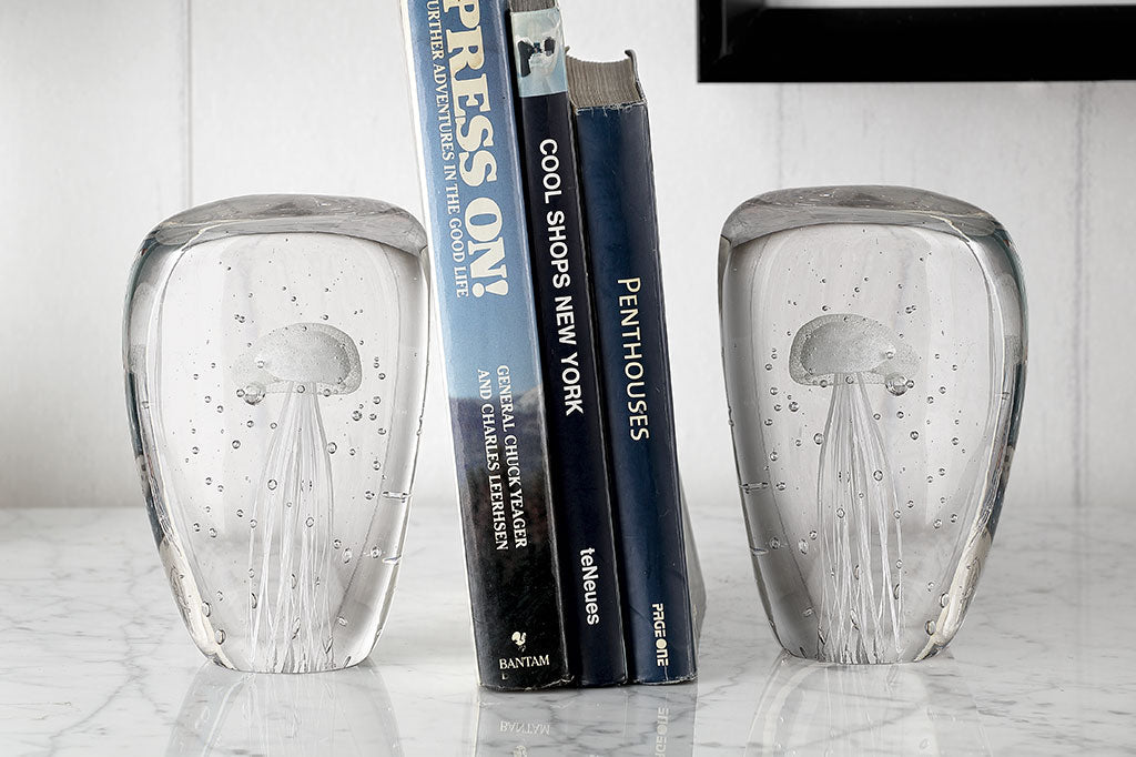 glass book ends with bubble and jellyfish design shown on table with books between