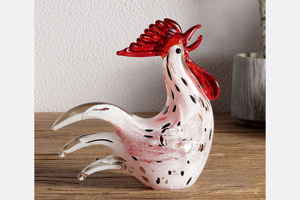 art glass rooster figurine shown on wood counter