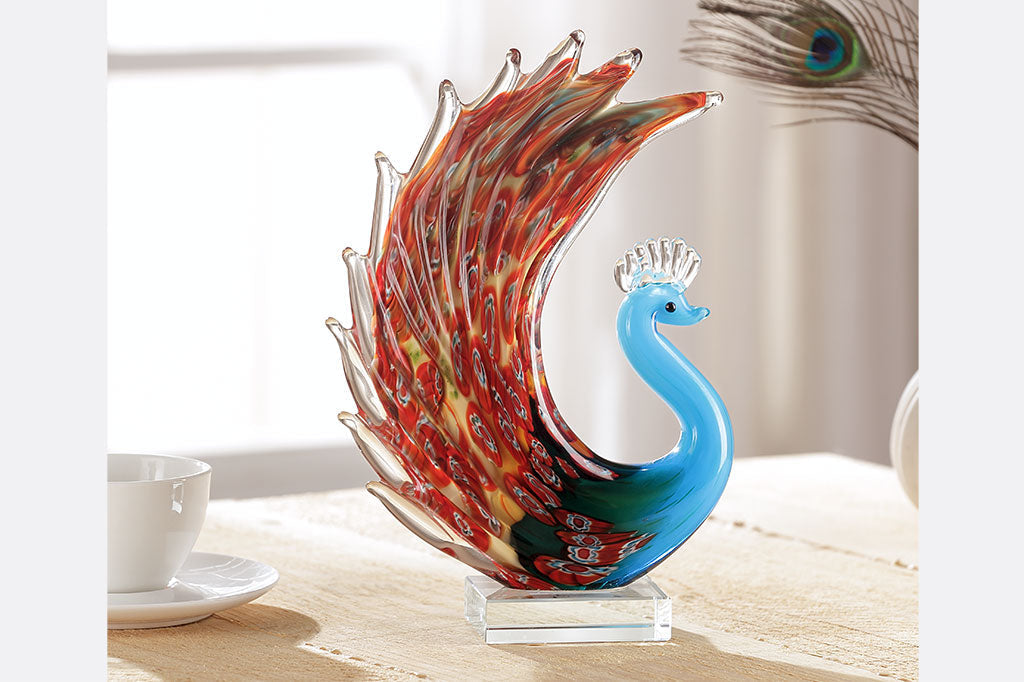 glass peacock with blue body and red swirling colors on feathers