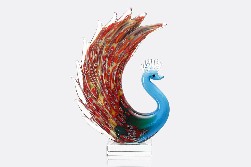 glass peacock with blue body and red swirling colors on feathers