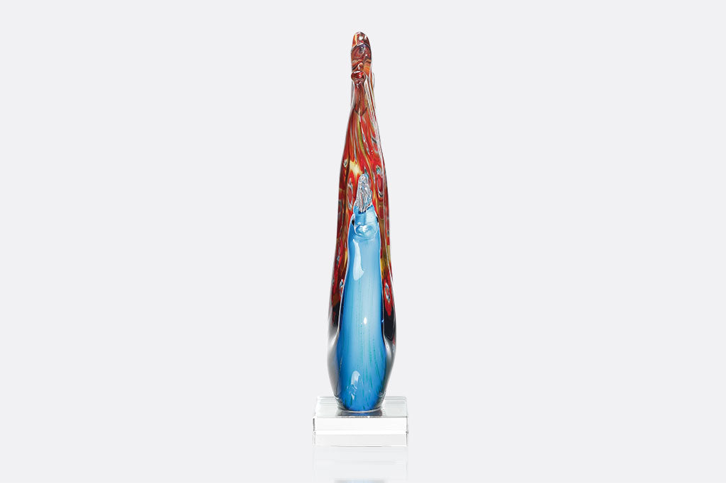 glass peacock with blue body and red swirling colors on feathers