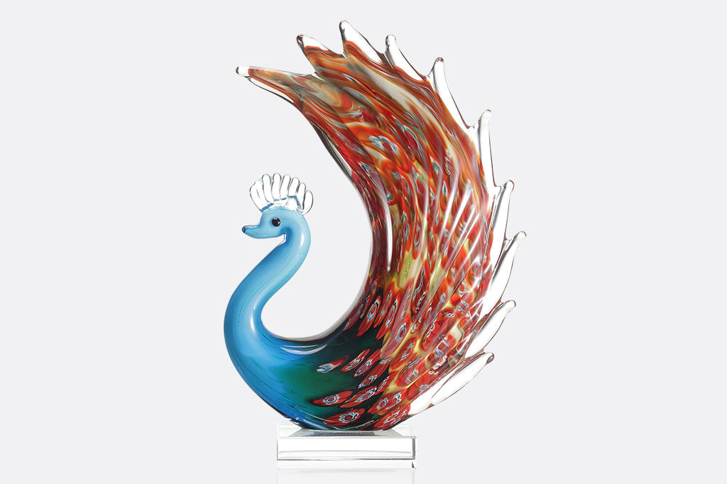 glass peacock with blue body and red swirling colors on feathers