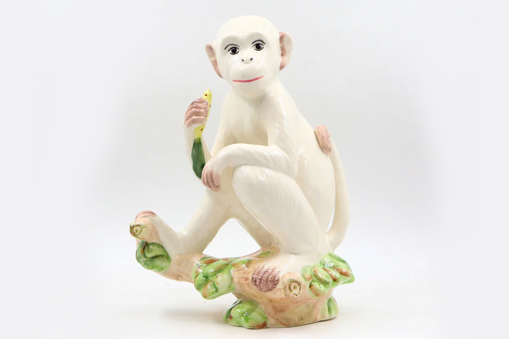 ceramic white monkey holding a banana