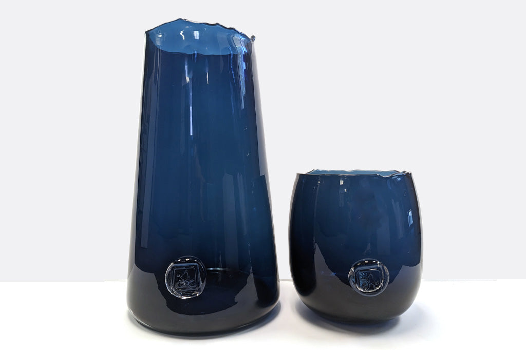 deeply saturated glass vase in rich blues; heavy glass with makers mark impression, wavy rim - reminescent of ocean waves - one tall, one short and bowl-like