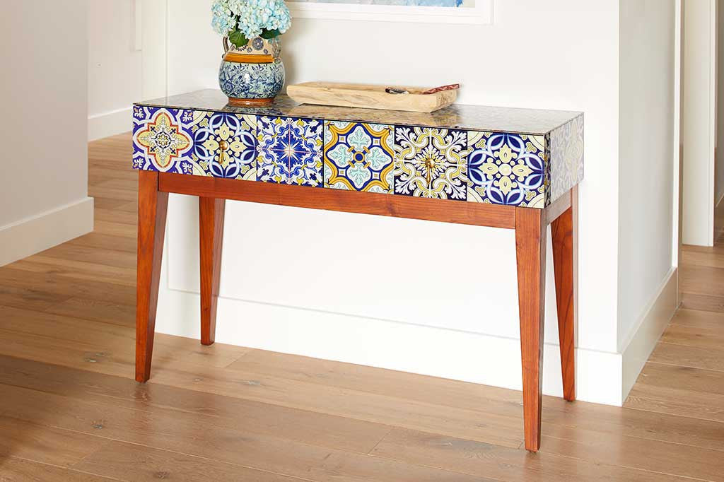 console table with blue and white tiles set against wall