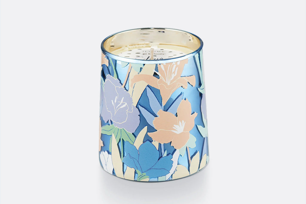 Glass candle vessel shown unlit, blue and peach floral motif