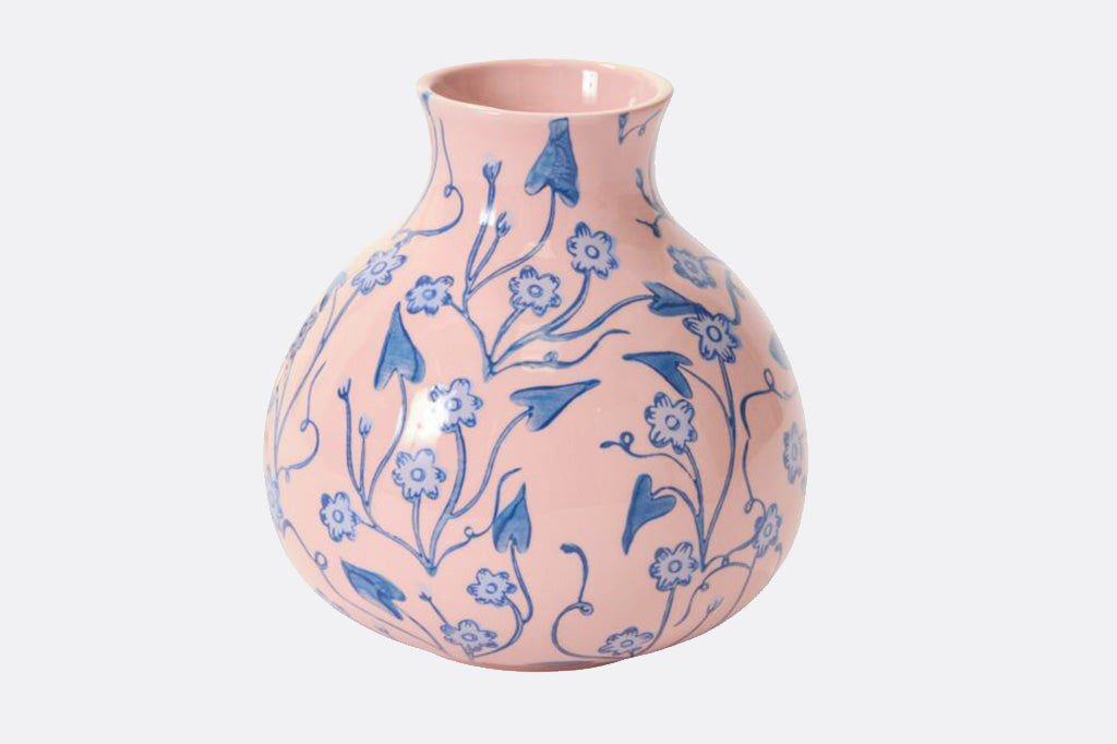 Ceramic vase with base color of pink and a vine and blossom blue floral design