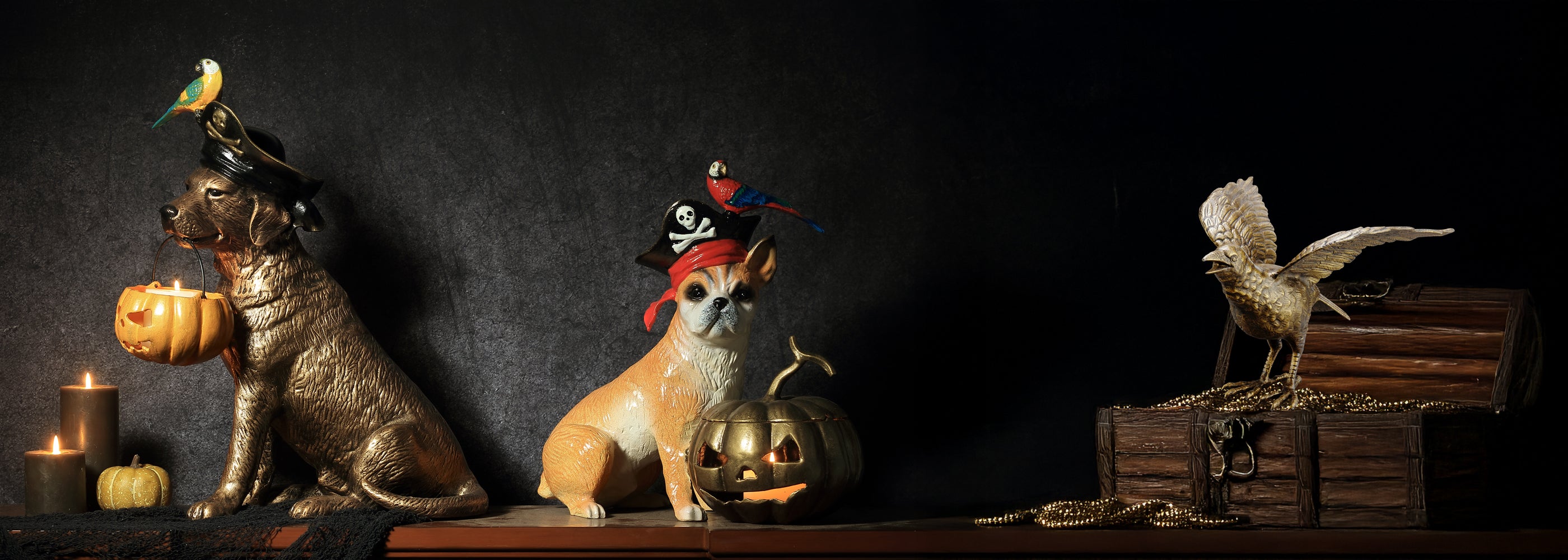 Halloween imagery with sculptures of two pirate dogs and large bronze raven atop a pirate chest