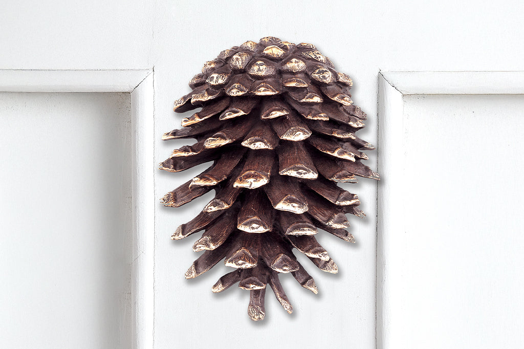 brass pinecone doorknocker placed on exterior door