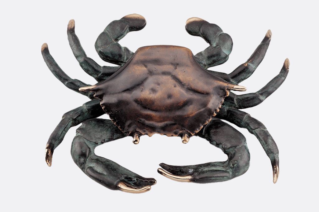 cast metal crab door knocker, tips of claws are gold. Body of crab is dark brown with rust colored highlights legs are a deep gray with blue highlights