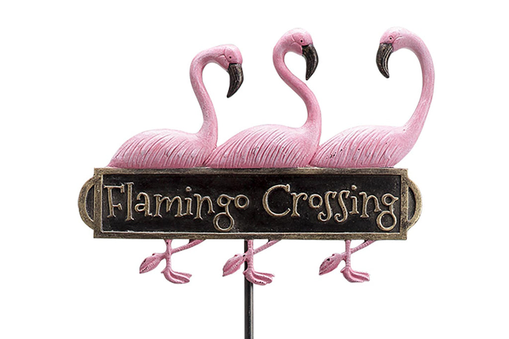 cast metal staked lawn sign reading "flamingo crossing" with three pink flamingos 