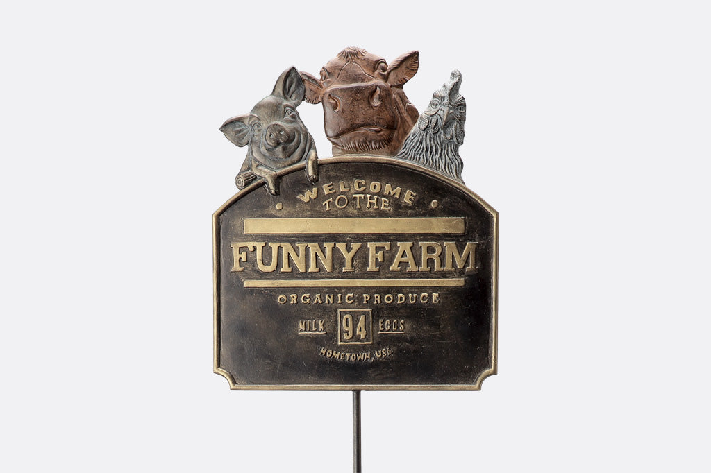 Decorative sign for 'Funny Farm' with animal figures on a white background