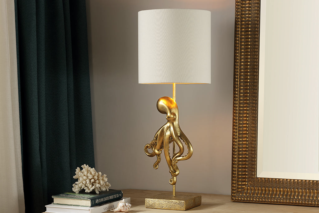 golden octopus lamp with white shade on table 