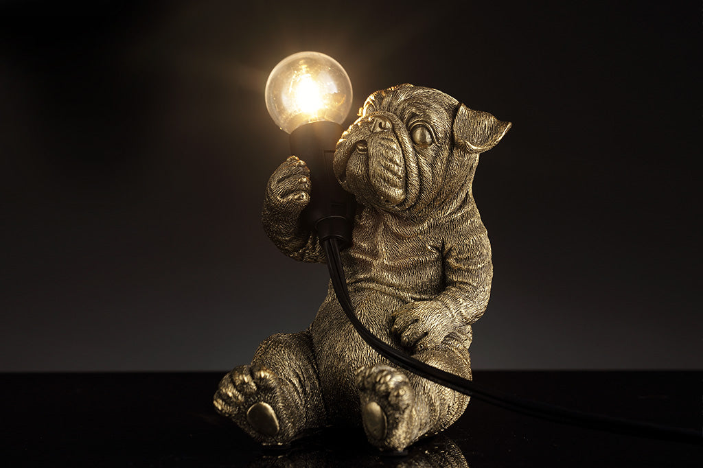 gold finished resin novelty desk lamp of french bulldog holding lightbulb.