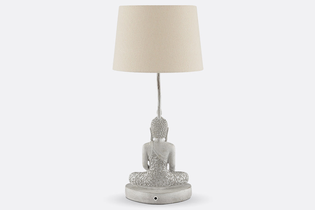 back view of cream colored Resin Buddha sculpture table lamp with cream fabric shade