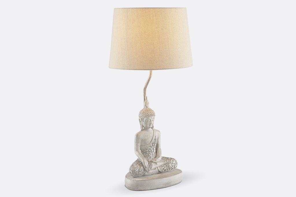 face right view of cream colored Resin Buddha sculpture table lamp with cream fabric shade