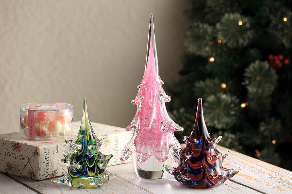 holiday table scene of three glass christmas trees in lavender, green/blue, and red/blue