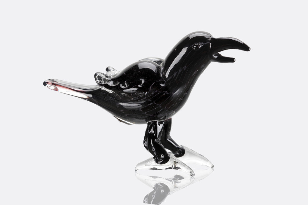 Black glass bird sculpture on a white background