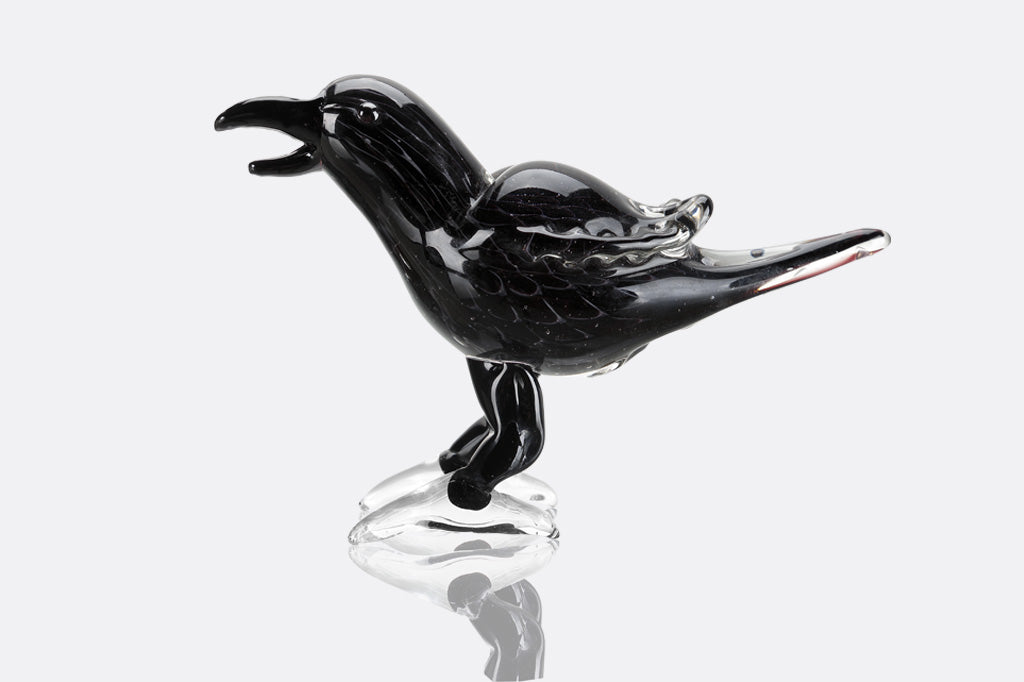 Black glass bird figurine on a white background