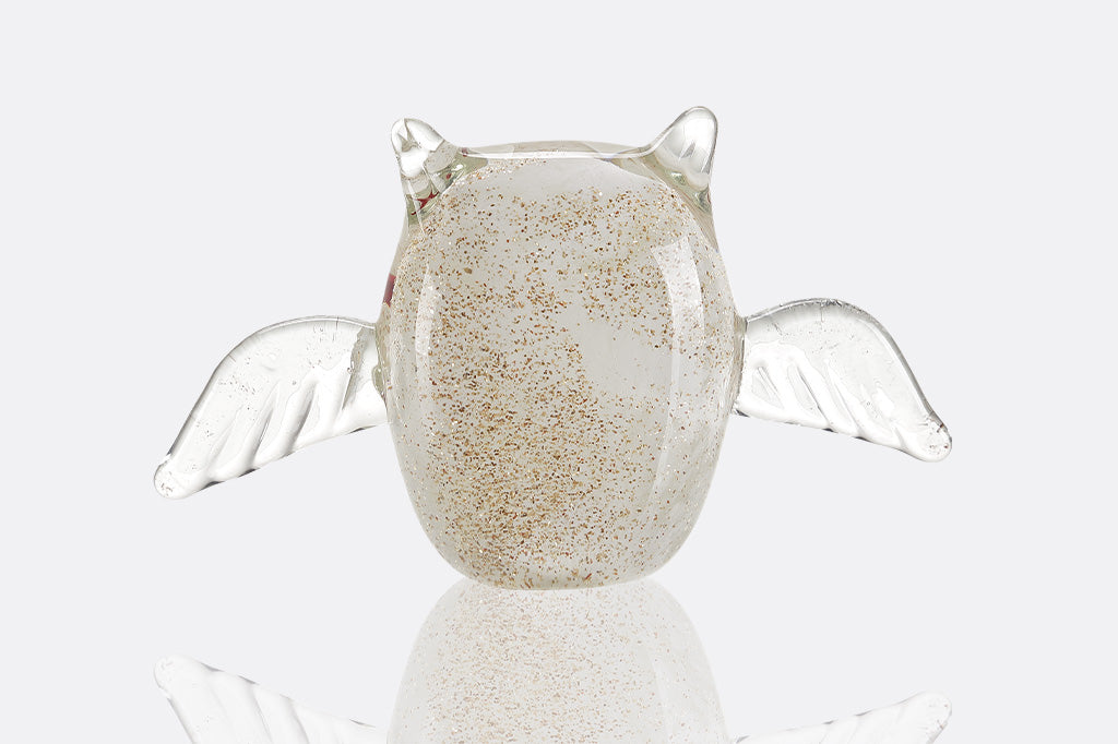 Glass figurine of a white and gold glitter bat with a smiling expression on a white background