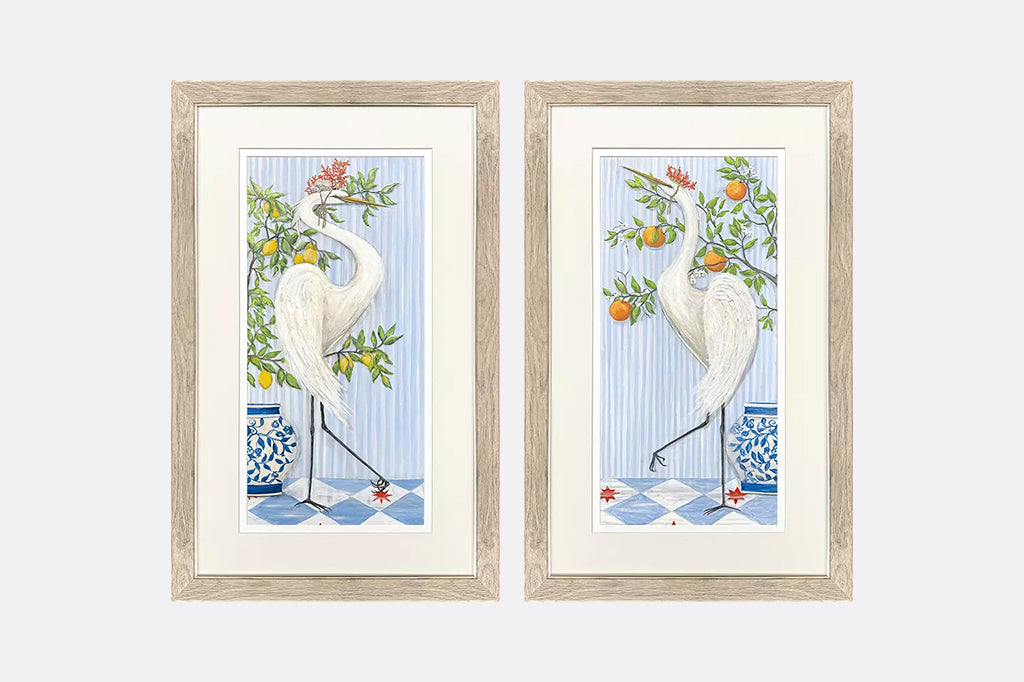Framed artwork of cranes wearing crowns made of coral next to fruit trees.