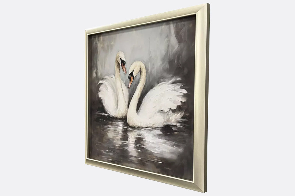 Framed artwork of two swans in water.