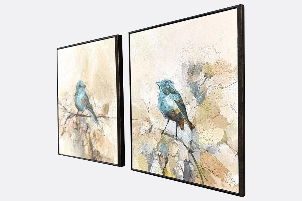 Two framed artworks of blue birds on a branch.