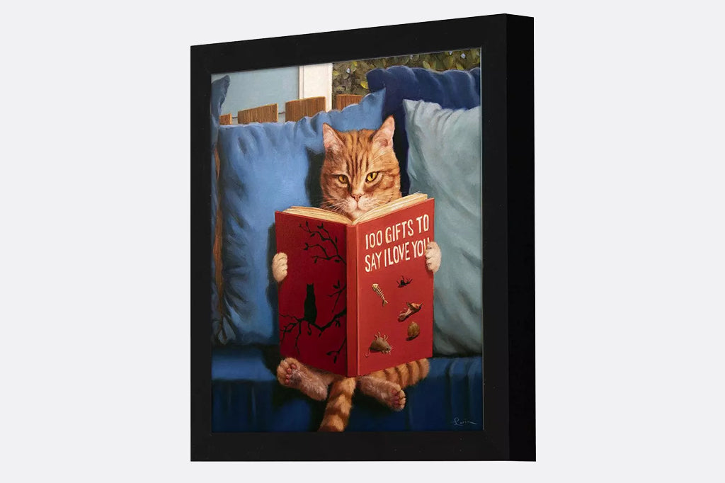 Cat sitting on a couch reading a book titled '100 Gifts to Say I Love You'.
