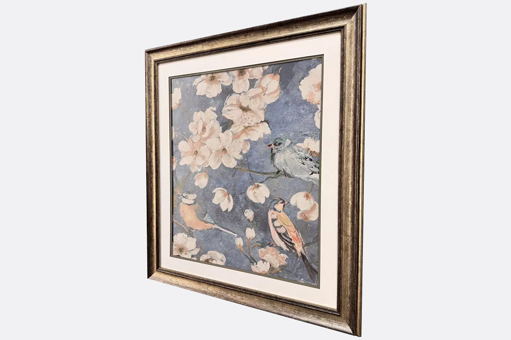 Framed artwork of three birds and flowers.