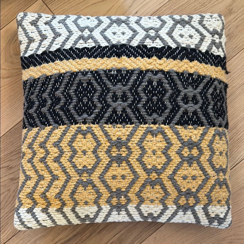 Decorative pillow with geometric pattern on a wooden floor