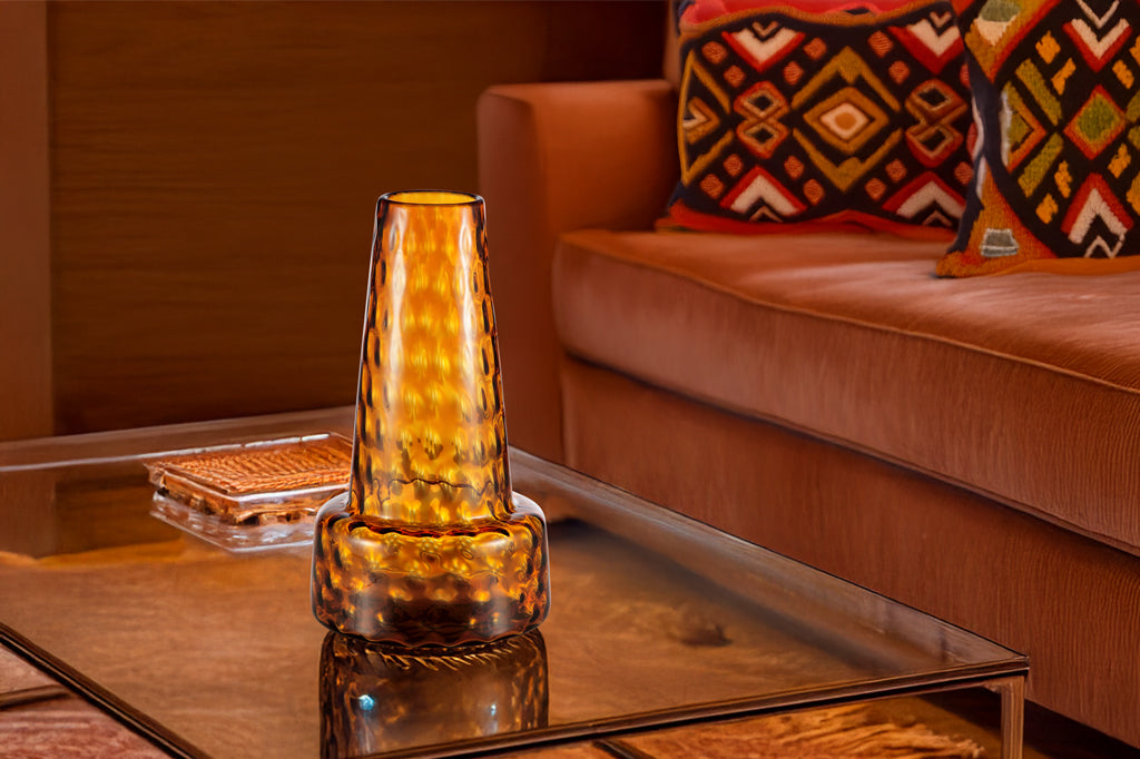 large ochre glass vase with textured dimples shown in livingroom with western colors and themed throw pillows