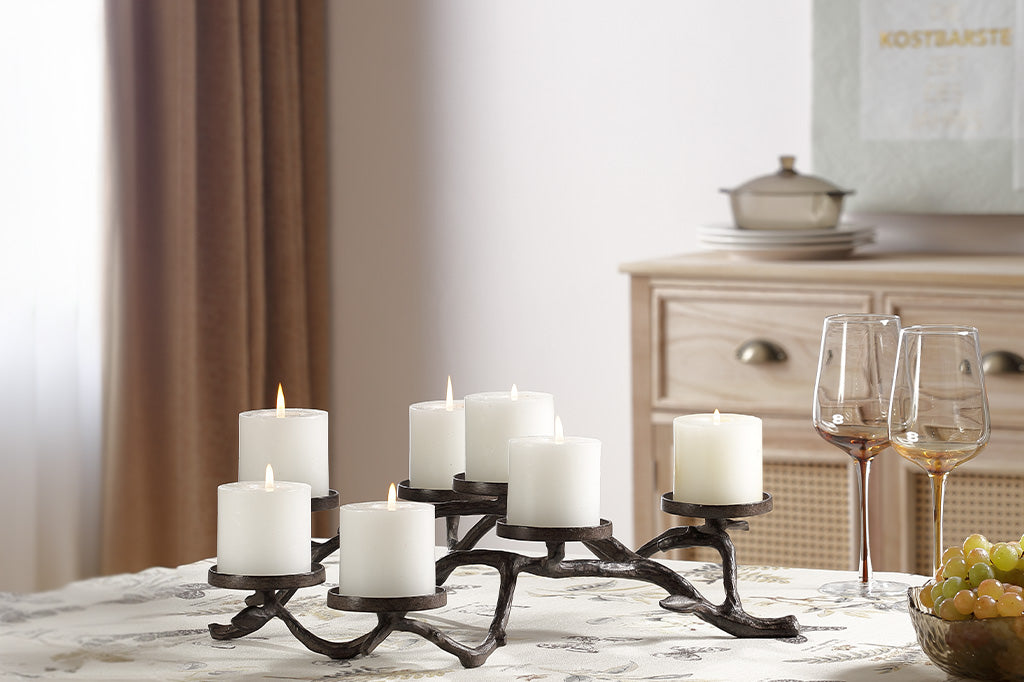 Madeira Pillar Candleholder shown on dining table with 7 candles. Two wine glasses and a bowl of grapes on table.