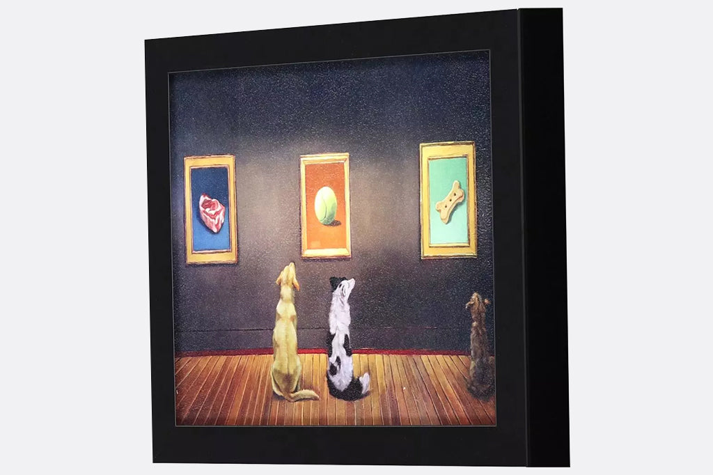 Framed artwork of three dogs looking at paintings on a wall of a steak, a ball, and a dog biscuit.