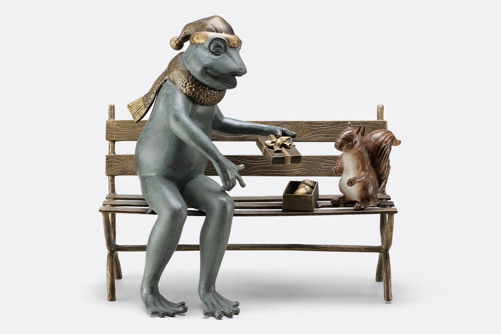 Frog and squirrel statue gifting an acorn on a bench