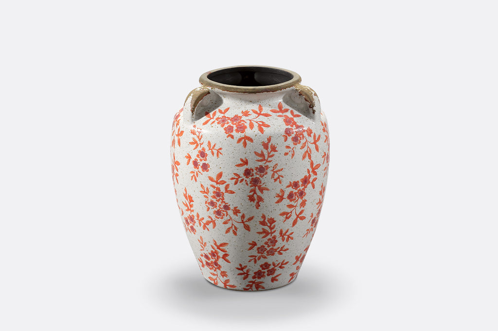 A vase jar with orange leaves and flowers.