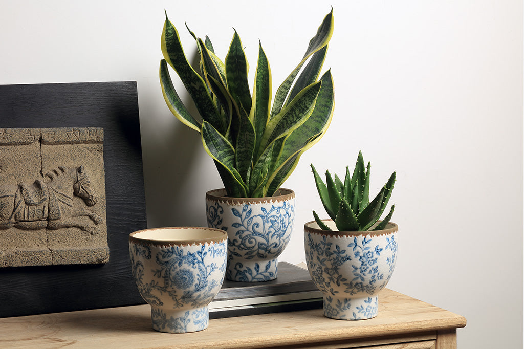 White and blue ceramic pots with flowers and vine designs.