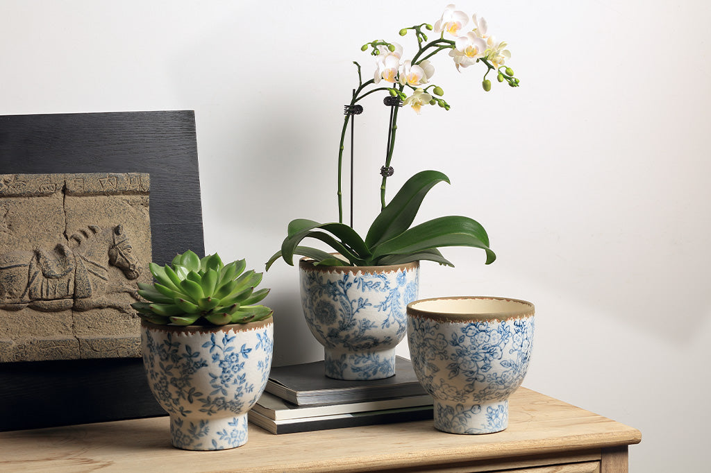 White and blue ceramic pots with flowers and vine designs.