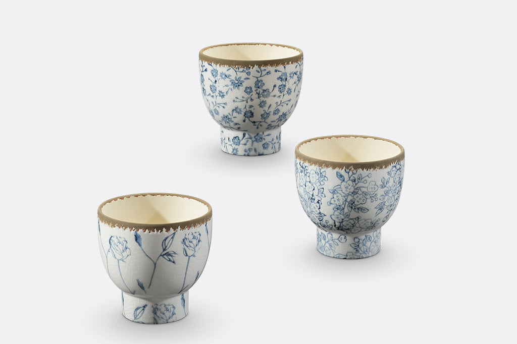 White and blue ceramic pots with flowers and vine designs.