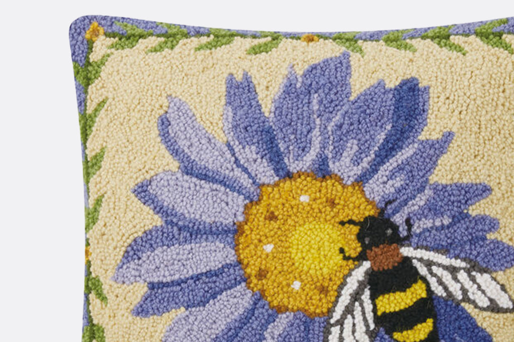 Detailed view of hooked pillow texture, highlighting the dimensional purple tones of the flower
