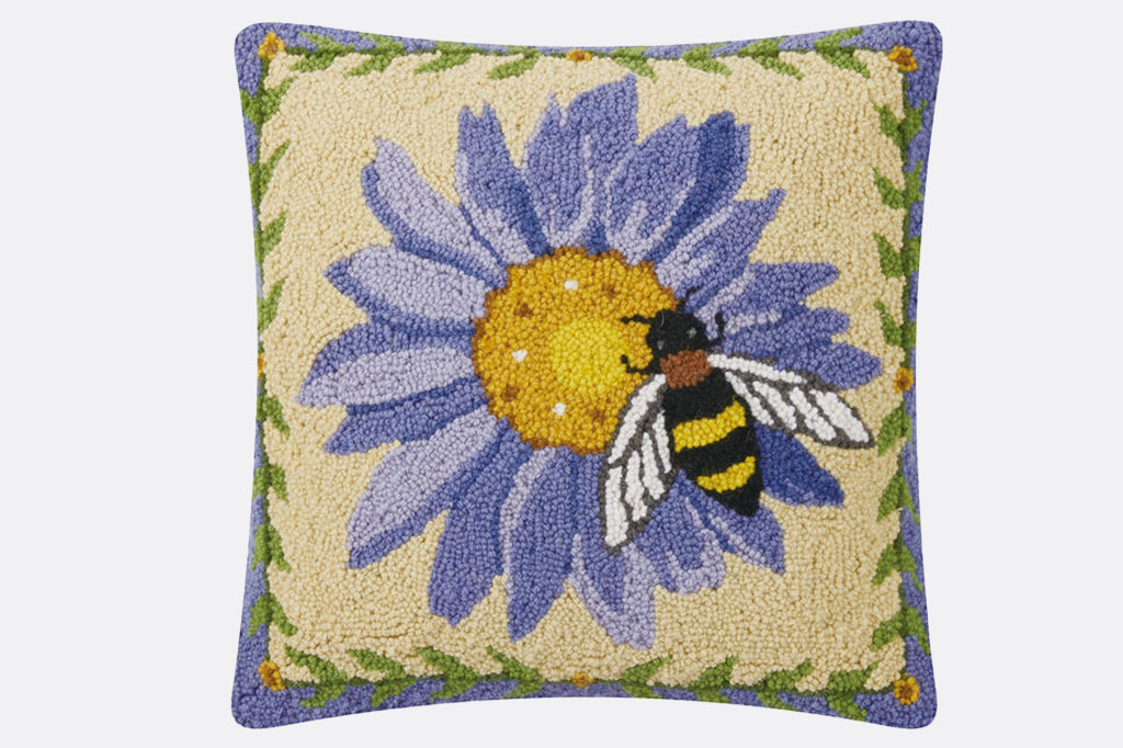 Hooked pillow with a sweet bee resting on a purple flower