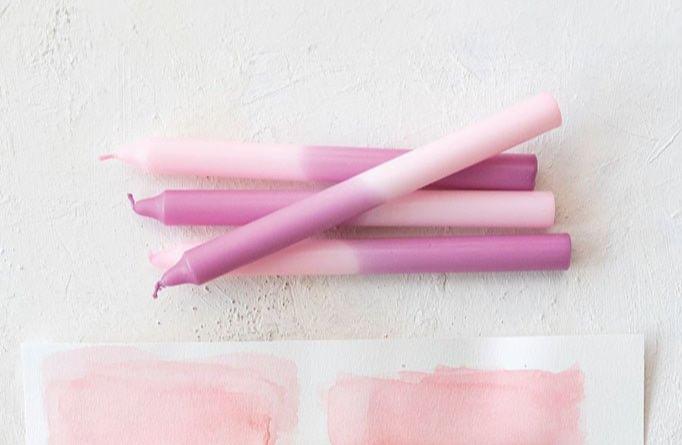 two toned candles of pink and purple, taper sized, box of 4 shown by other multicolored tapers