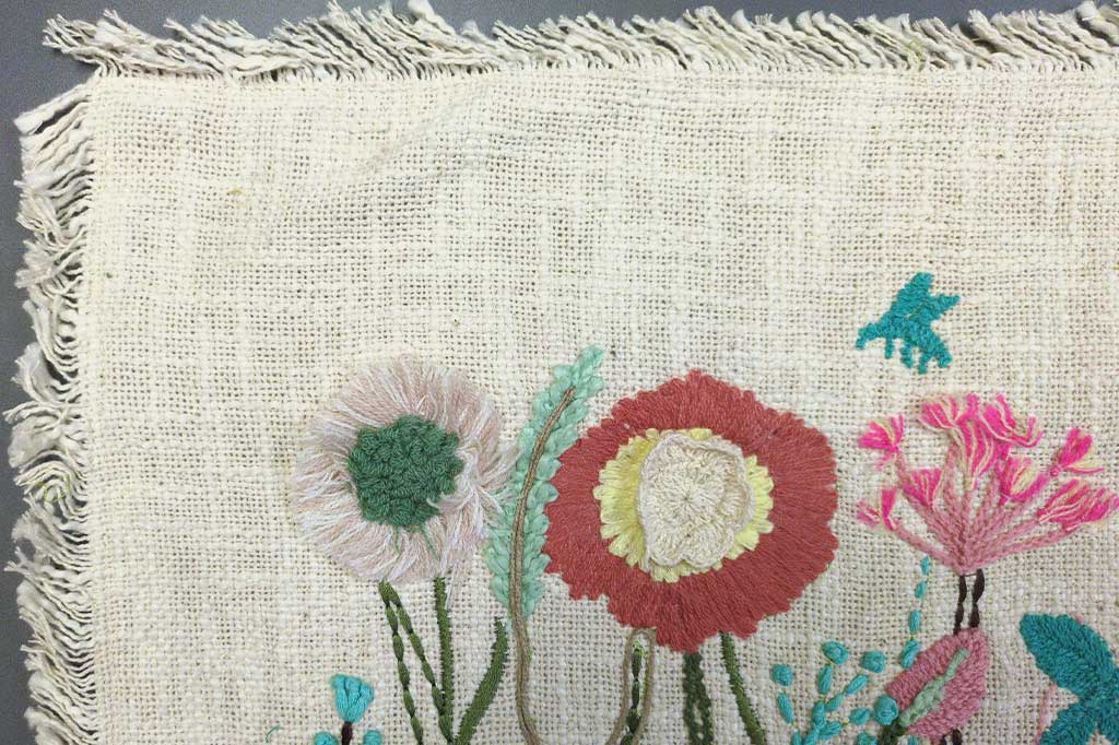 floral lumbar pillow case showing closeup view of tufting, fringe, and embroidery