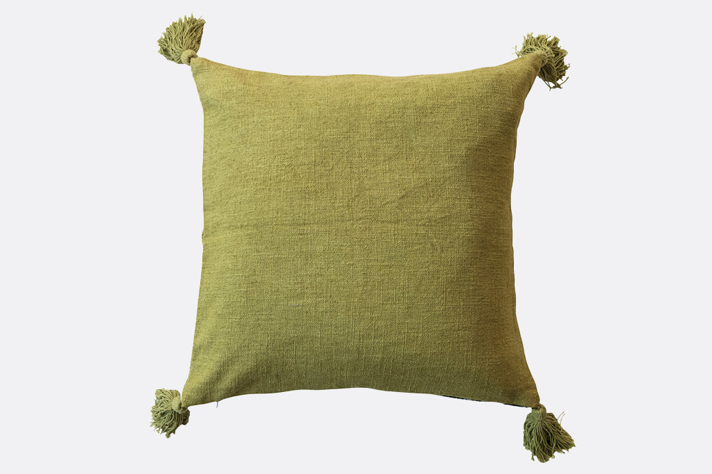 back of green pillow with tassels on all four corners 