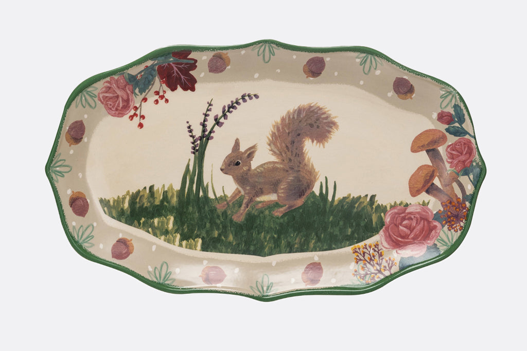 ceramic serving plate, featuring a squirrel in a grassy meadow. The plater rim features acorns, roses and mushrooms 