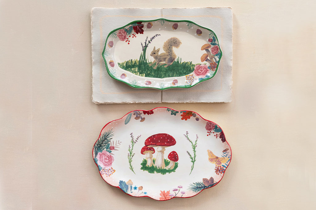 ceramic serving plate, featuring a squirrel in a grassy meadow. The plater rim features acorns, roses and mushrooms