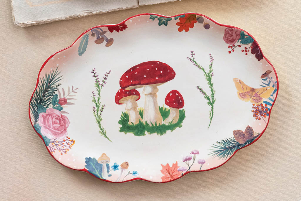 ceramic serving tray with printed mushroom and pine needle print set on counter 