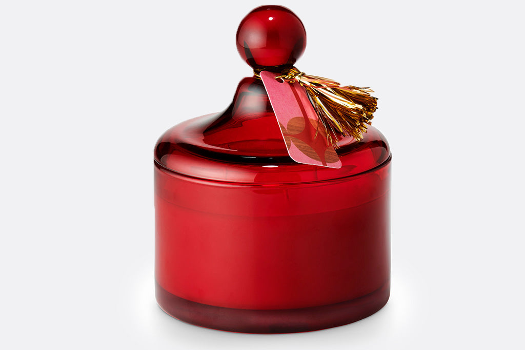 Red glass lidded candle shown with gold tassle tag